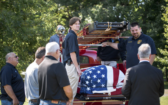 Joe Heller’s coffin is carried on the Essex Fire Department’s 1941 Mack firetruck that Heller helped restore, in Connecticut.