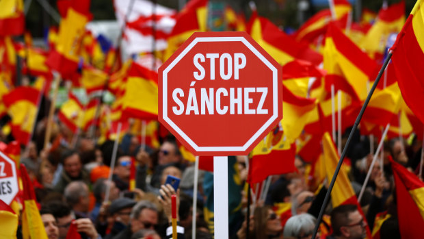 Demonstrators hold banners and Spanish flags during a protest in Madrid, Spain, on Sunday.