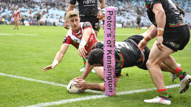 Tough start: Greg Inglis crosses in the corner to welcome Zac Lomax (background) to the top grade.