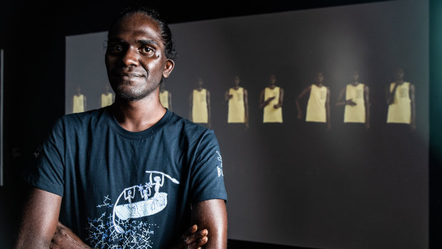 Artist Gutingarra Yunupingu, winner of the Telstra Multimedia Award in front of his piece, Gurrutu'mi Mala - My connections.