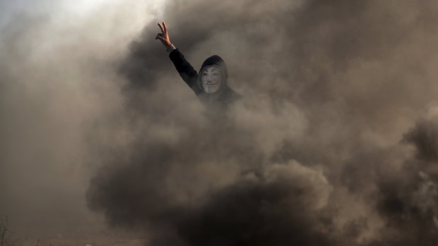 A Palestinian protester flashes the V sign during a protest near the Gaza Strip border with Israel, in eastern Gaza City, on Saturday.