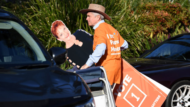 Former One Nation senator Malcolm Roberts arrives at a polling station in Caboolture, in the Queensland seat of Longman, with a carboard cutout of senator Pauline Hanson.