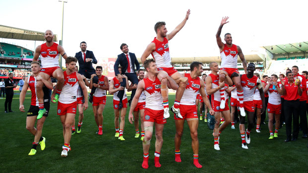 Wearing opposition colours didn’t stop Dan Hannebery (far left) from being involved in a great moment in Swans history three years ago.