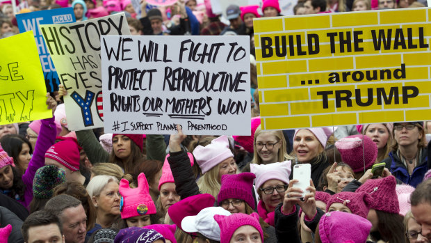 Women with bright pink hats and signs make their voices heard on the first full day of Donald Trump's presidency, Saturday, January 21, 2017.