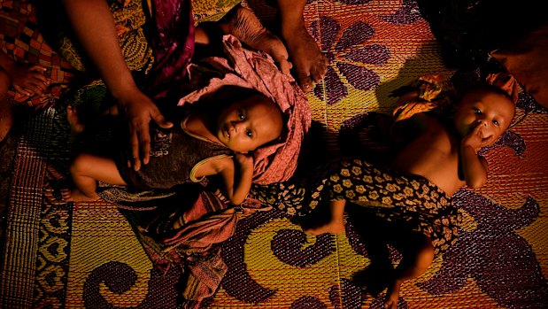 Fatima Begum comforts her twins Asia and Rubina in their shelter in Balukhali camp.