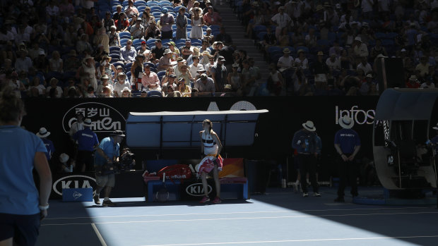 Petra Kvitova waits as officials close the roof on Rod Laver Arena.