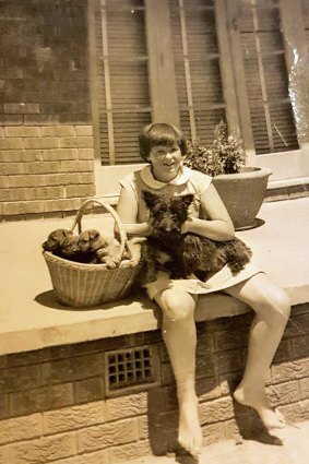 The writer in 1959, aged 11, with her Scottie dog, Flora, and pups in the family egg basket.