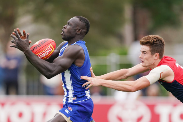 The Kangaroos' Majak Daw marks ahead of Bayley Fritsch of the Demons on Friday.
