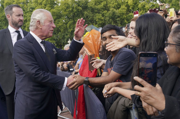 Kral Charles, Buckingham Sarayı'nın önünde kalabalığı selamlıyor.