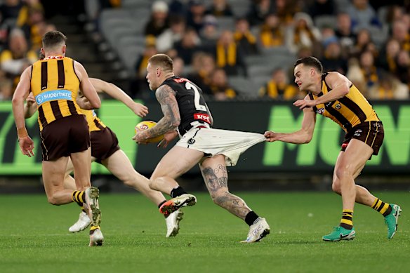 Jordan De Goey of the Magpies is tackled by Karl Amon of the Hawks.