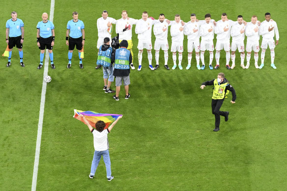A protester waves a rainbow flag to the Hungarian team before the match against Germany at Munich’s Allianz Arena.