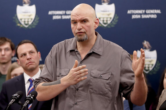 John Fetterman speaks as he stands beside Josh Shapiro during a news conference in 2020.