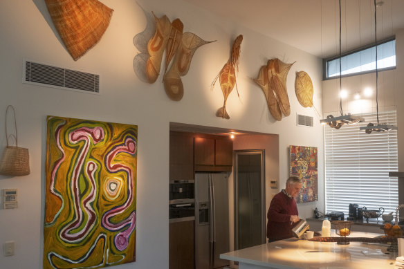 Michael Horton in the kitchen among many weavings from across Australia, including works from Maningrida Art Centre, Northern Territory.