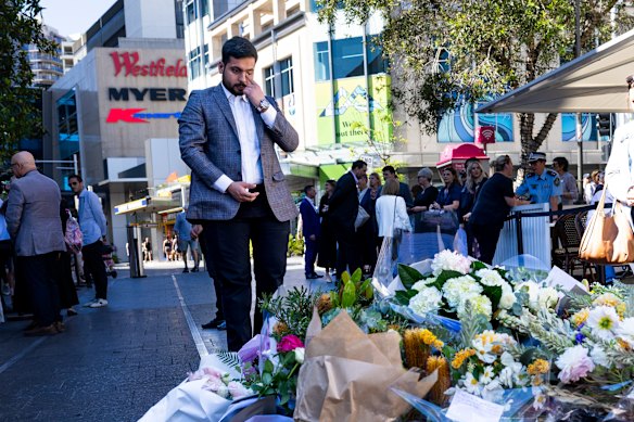 Surviving security guard Muhammad Taha shed a tear as he left a bouquet.