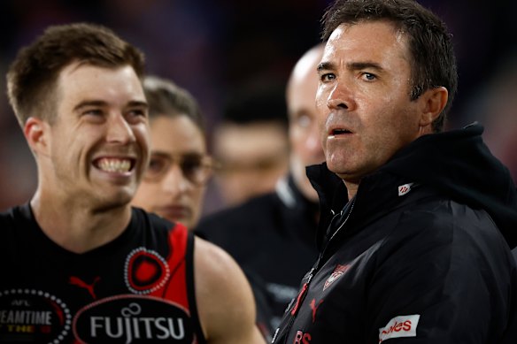 Bombers coach Brad Scott, right, speaks to his players.