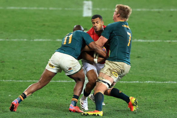 Anthony Watson of the British & Irish Lions is tackled by Peiter-Steph du Toit (R) and Makazole Mapimpi.