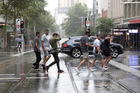 People run through the rain on George Street on Friday.