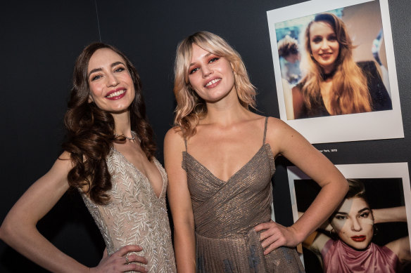 Lizzy and Georgia May Jagger posing in front of the Polaroid shot of their mum, Jerry Hall, which was taken by Maripol. 