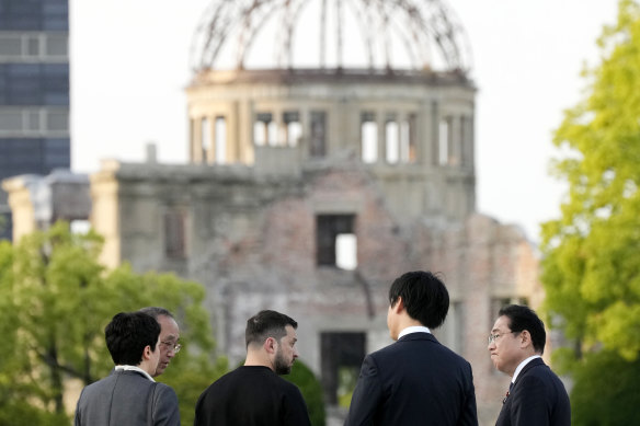 Ukrainian President Volodymyr Zelensky (third from left) and Japanese Prime Minister Fumio Kishida (right) talk in front of the Cenotaph for the Victims of the Atomic Bomb at the Hiroshima Peace Memorial Park.