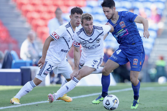 Callum McManaman of Melbourne Victory is tackled by Newcastle’s Connor O’Toole.