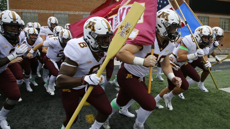 Minnesota players run out before a college football game last month.