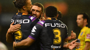 Win-WIN: Sandor Earl, Kenny Bromwich and Justin Olam celebrate the Storm's win on Thursday night in Wollongong.