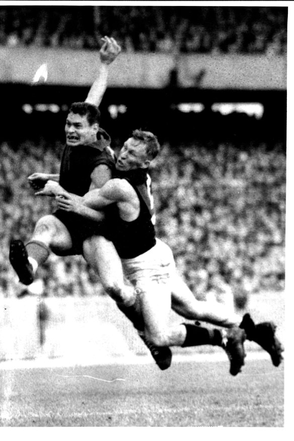 An iconic image of Ron Barassi kicking a brilliant goal while being tackled by Essendon’s Bob Suter in 1957.