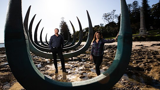 Alison Page and Dillon Kombumerri with sculpture 'The Eyes of the Land and Sea' at Captain Cook's landing place in Kamay Botany National Park. 