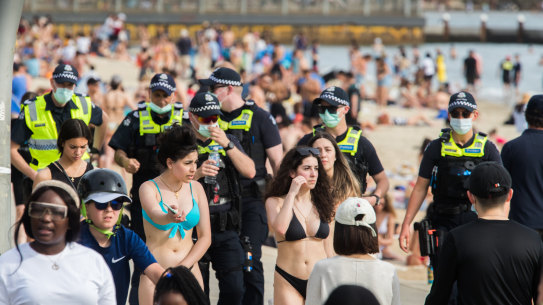 Crowds and police on St Kilda Beach.