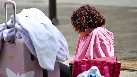 A homeless person sits outside a cyclone refuge centre in Brisbane, on March 7, as the city prepares for the arrival of cyclone Alfred.