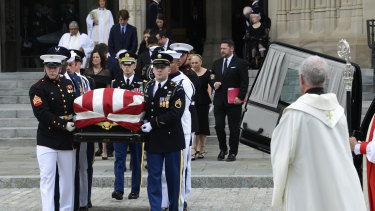 The coffin of Senator John McCain, followed by family members, is carried out of Washington National Cathedral in Washington, on Saturday.