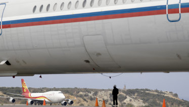 A Chinese airplane is framed by the fuselage of a Russian airplane at the Simon Bolivar International Airport in Maiquetia, near Caracas, Venezuela.