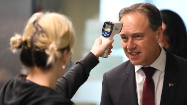 Federal Health Minister Greg Hunt has his temperature checked before touring the Royal Melbourne Hospital on Thursday.