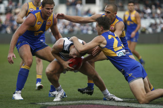 Joel Selwood is tackled by the Eagles’ Alex Witherden.