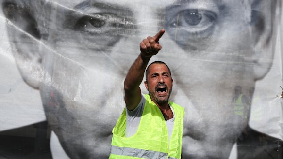 A man chants slogans next to a banner showing Israeli Prime Minister Benjamin Netanyahu during a protest against the rising cost of living, in Tel Aviv recently.