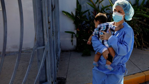 Nurse Claudia Rivas, cradling her son, arrives to receive a dose of the Sputnik V COVID-19 vaccine, as part of a vaccination campaign in Tegucigalpa, Honduras.