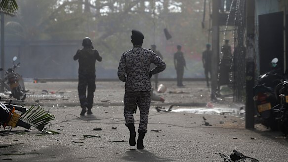 Sri Lankan security forces approach the site after a vehicle parked near St Anthony's shrine exploded in Colombo on Monday.