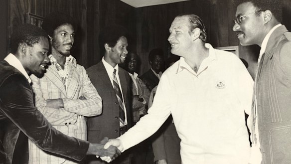 Kerry Packer meets the West Indies cricket team, among them Clive Lloyd to his left and opposite him with his arms folded, Michael Holding, as World Series Cricket gets going in 1977.