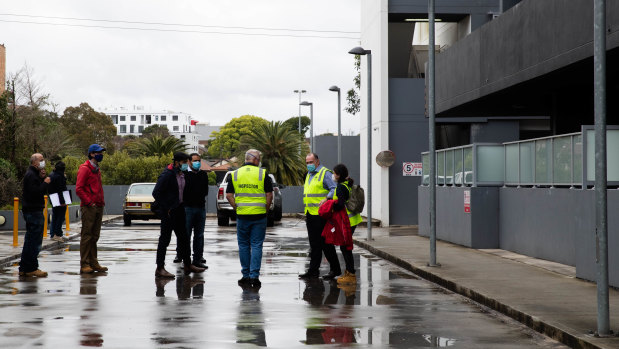 Building inspectors gather outside the Charles Street development on Wednesday afternoon.