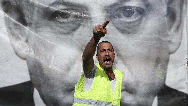 A man chants slogans next to a banner showing Israeli Prime Minister Benjamin Netanyahu during a protest against the rising cost of living, in Tel Aviv recently.