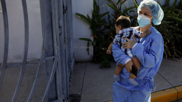 Nurse Claudia Rivas, cradling her son, arrives to receive a dose of the Sputnik V COVID-19 vaccine, as part of a vaccination campaign in Tegucigalpa, Honduras.