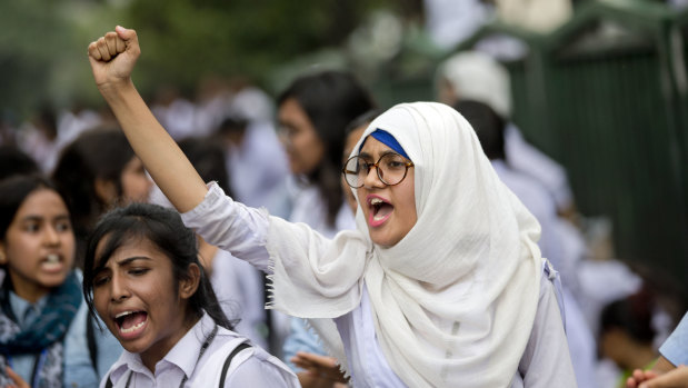 Bangladeshi students shout slogans as they block a road during a protest in Dhaka, Bangladesh, on Saturday