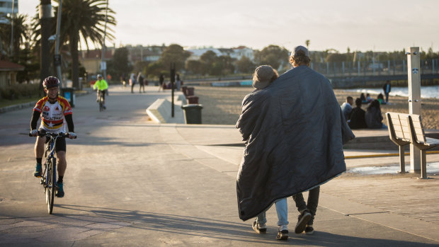 Brothers Bela and Noah from the Netherlands wander along St Kilda beach at dawn. 