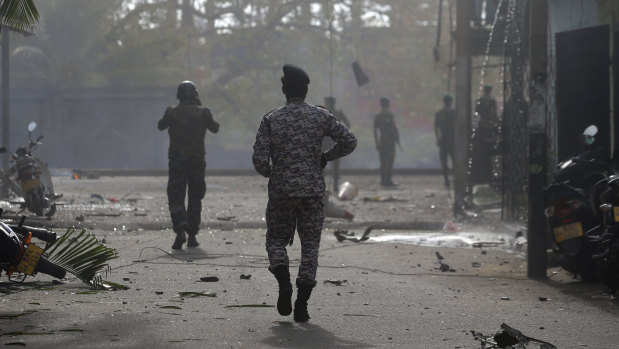 Sri Lankan security forces approach the site after a vehicle parked near St Anthony's shrine exploded in Colombo on Monday.