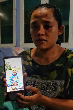 Nikita, stranded at the airport in Makassar, Sulawesi,  holds a photo of Zidan her two-year-old son, who has been missing since the earthquake.
