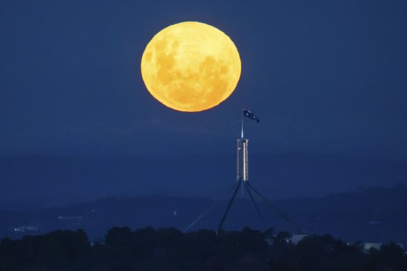 A ‘supermoon’ rises over Canberra with Parliament House in the foreground on Tuesday.