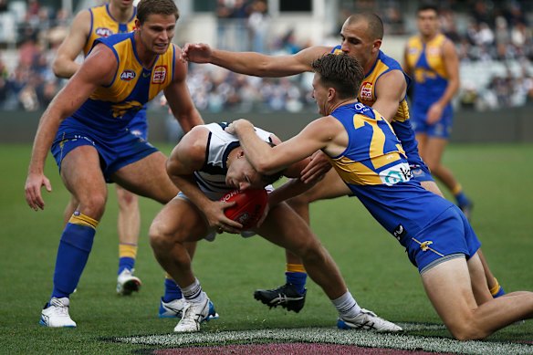 Joel Selwood is tackled by the Eagles’ Alex Witherden.