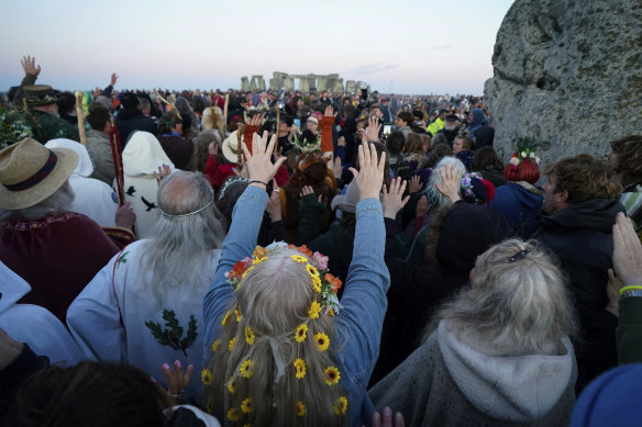 People gather around the Heel Stone ahead of sunrise.