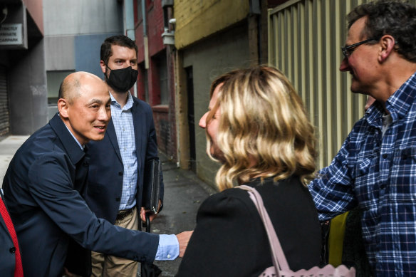 Yan Qiu shakes hands with the family of the building’s former owners after buying it in 2021. Qiu’s company Aqua Greenland owns the three accompanying sites as well.
