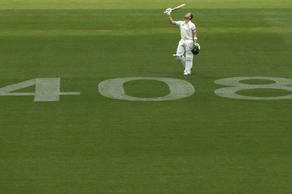Smith raises his bat to the sky after reaching a century against India at Adelaide following Phillip Hughes’ death in 2014.